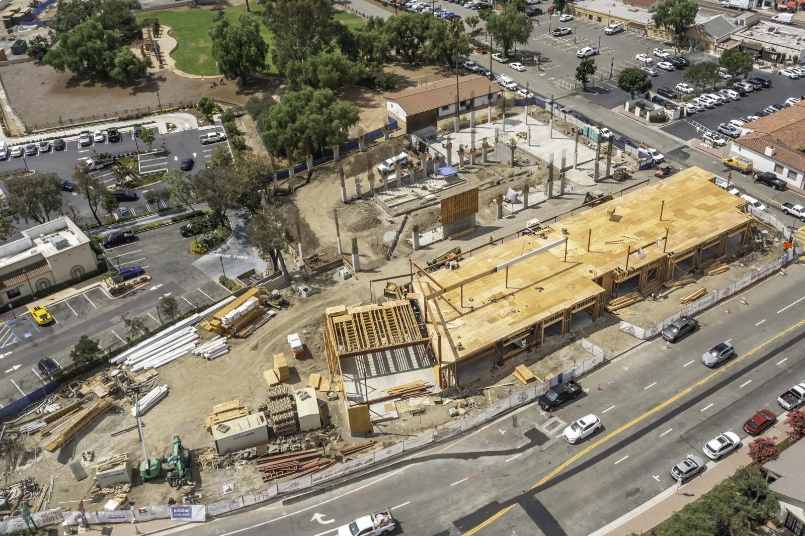 Street-facing wood framing and deck at Mission Place with concrete slab areas and upright columns behind the structure.
