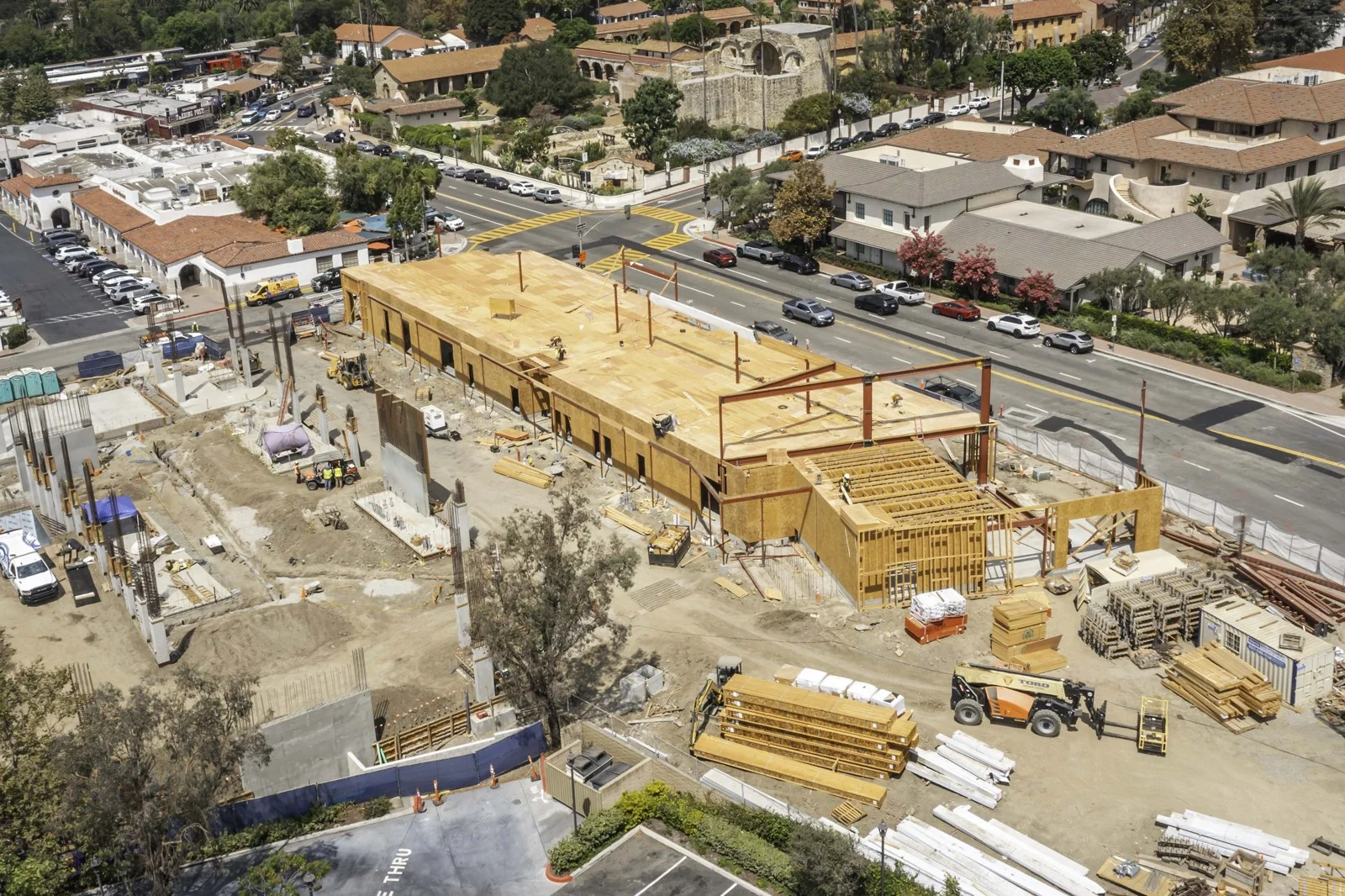 Closer elevated view of Mission Place showing wood roof decking, red steel members, exposed framing and concrete work.
